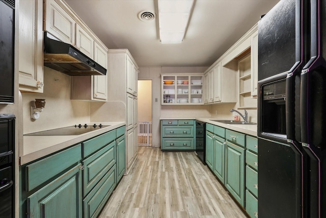 kitchen with sink, green cabinetry, light wood-type flooring, white cabinets, and black appliances