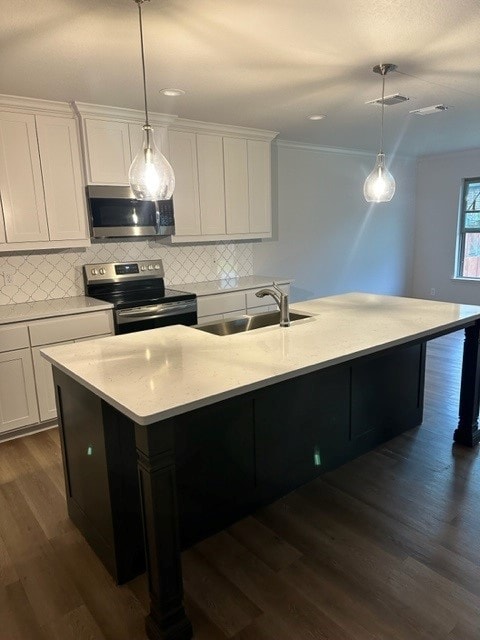 kitchen with sink, dark wood-type flooring, decorative light fixtures, and appliances with stainless steel finishes