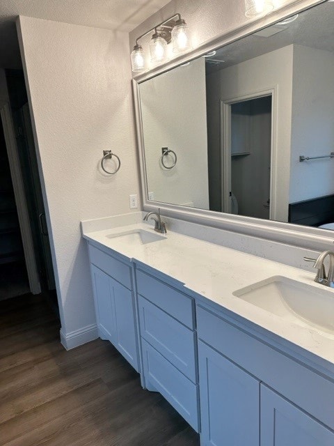 bathroom with hardwood / wood-style floors, vanity, and a textured ceiling