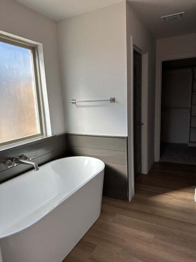 bathroom featuring wood-type flooring and a tub