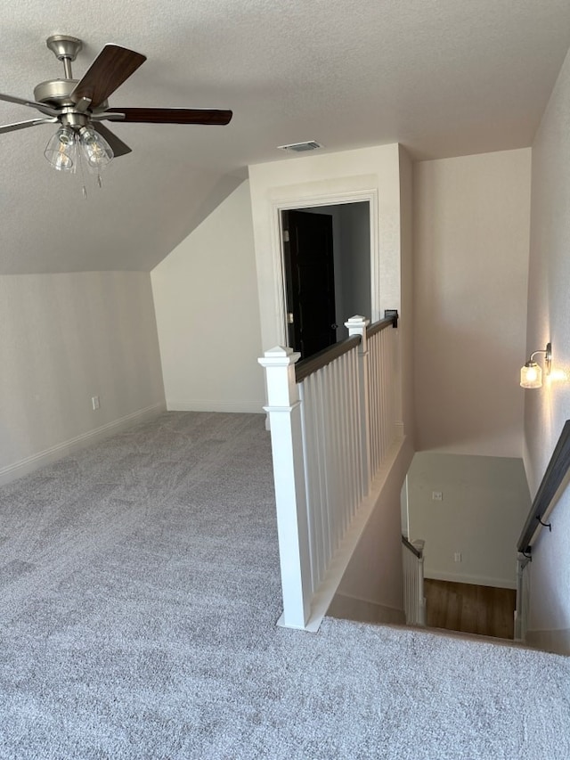 bonus room with carpet flooring, ceiling fan, lofted ceiling, and a textured ceiling