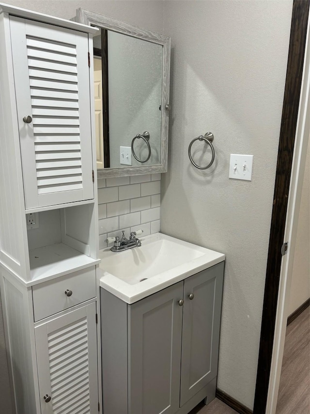 bathroom featuring vanity and decorative backsplash