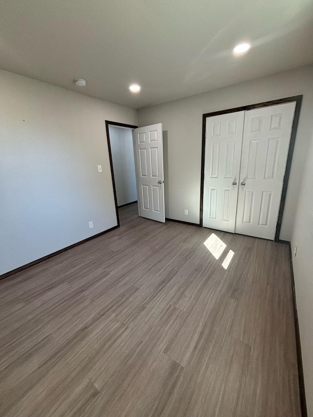 unfurnished bedroom with light wood-type flooring and a closet