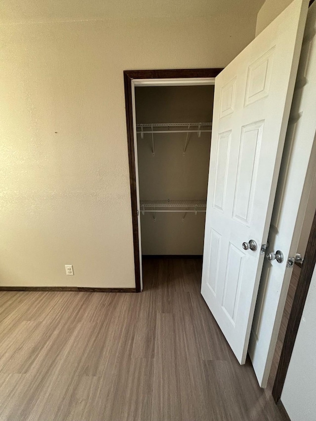 unfurnished bedroom featuring dark wood-type flooring and a closet