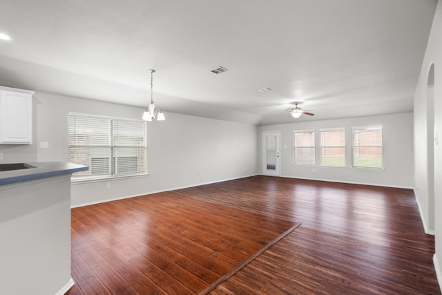 unfurnished living room featuring dark hardwood / wood-style floors and ceiling fan with notable chandelier