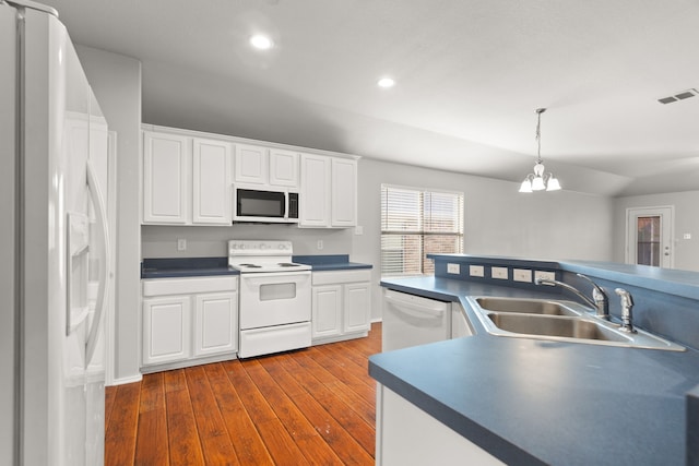 kitchen featuring white cabinetry, sink, dark wood-type flooring, an inviting chandelier, and white appliances