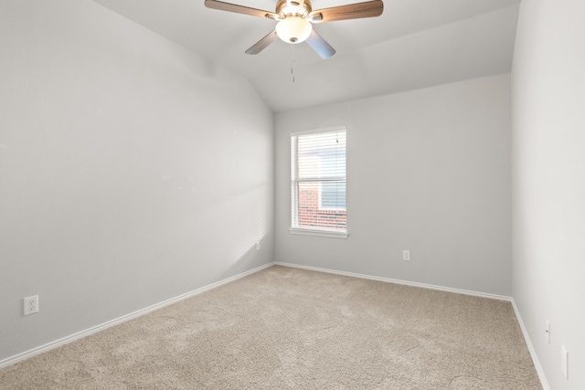 carpeted spare room featuring ceiling fan and lofted ceiling