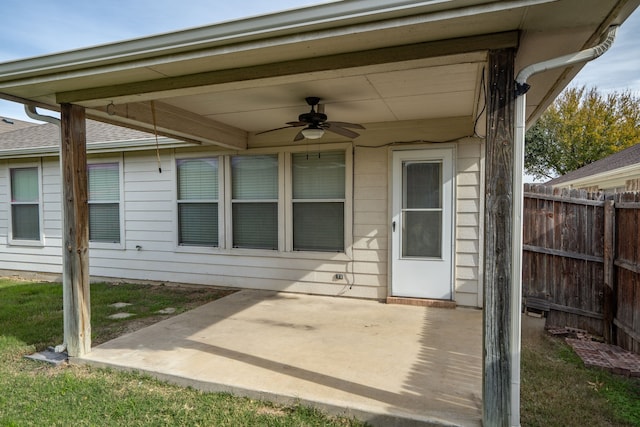 view of exterior entry with ceiling fan and a patio