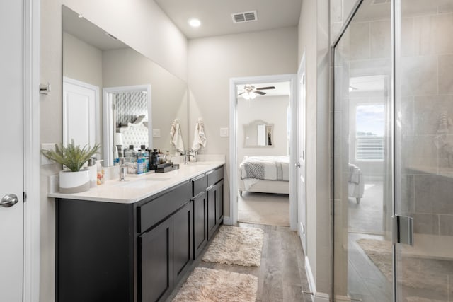 bathroom featuring vanity, hardwood / wood-style floors, a shower with shower door, and ceiling fan