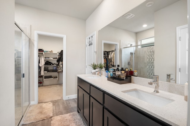 bathroom with hardwood / wood-style flooring, vanity, and a shower with shower door