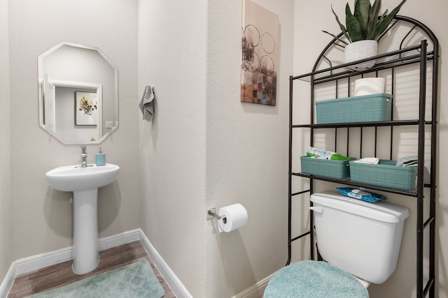 bathroom featuring toilet and wood-type flooring