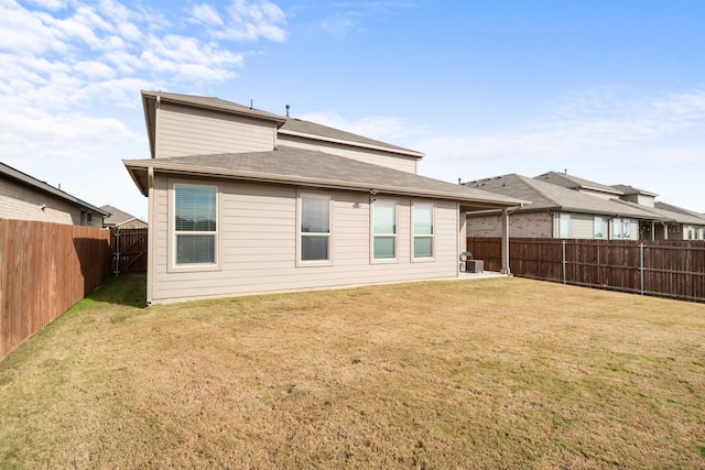 rear view of house with cooling unit and a yard