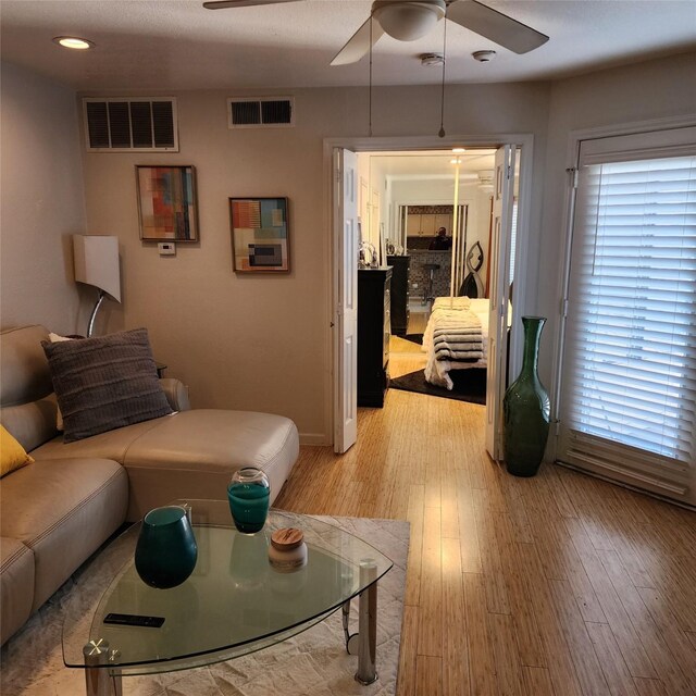 living room with ceiling fan and light wood-type flooring