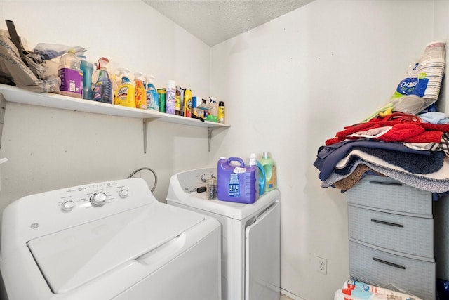 laundry area with a textured ceiling and washing machine and dryer