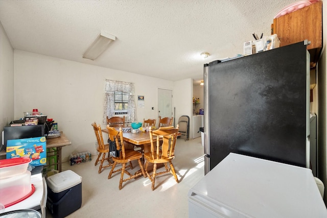 dining space with concrete flooring and a textured ceiling