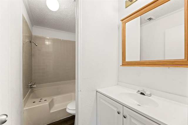 full bathroom with vanity, toilet, a textured ceiling, and tiled shower / bath