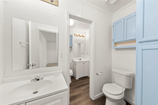 137 Montego Dr, Mesquite, TX 75149 - half bath featuring toilet, a textured ceiling, crown molding, vanity, and wood finished floors