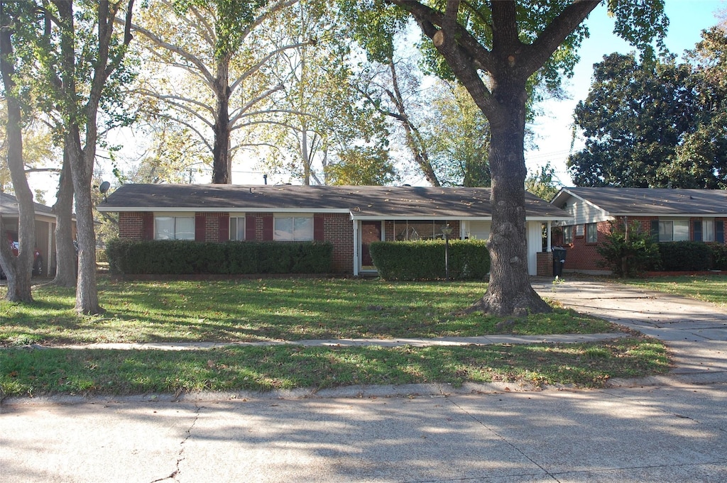 ranch-style home with a front lawn