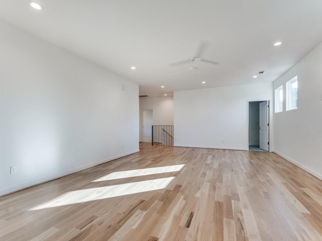 empty room with ceiling fan and light hardwood / wood-style floors