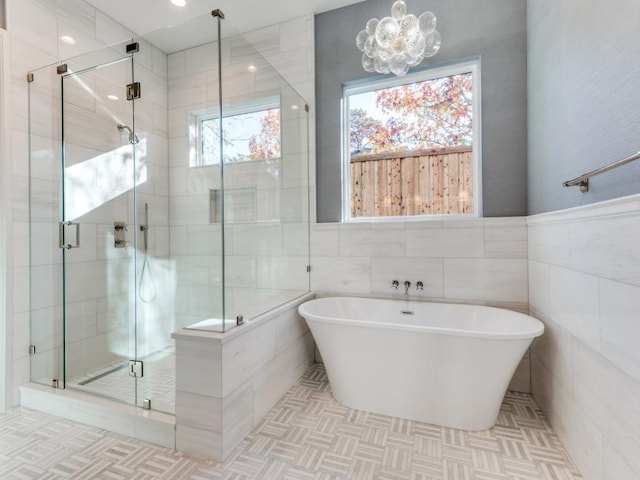 bathroom featuring tile walls and plus walk in shower