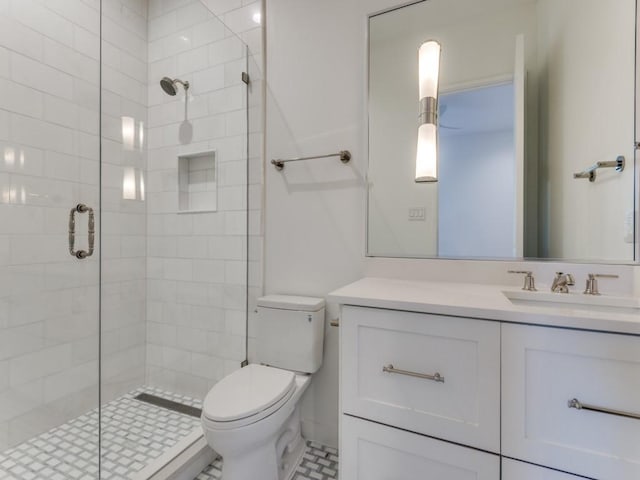 bathroom featuring tile patterned flooring, vanity, toilet, and a shower with shower door