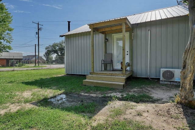 view of outbuilding with ac unit and a yard