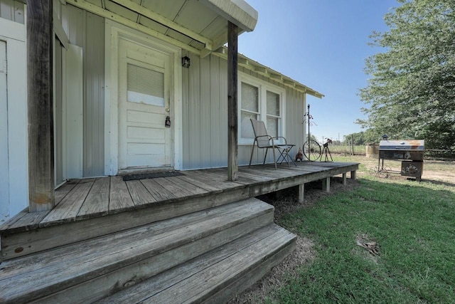 property entrance with a lawn and a wooden deck