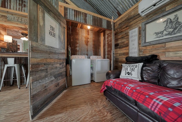 sitting room featuring independent washer and dryer, an AC wall unit, ceiling fan, and wood walls