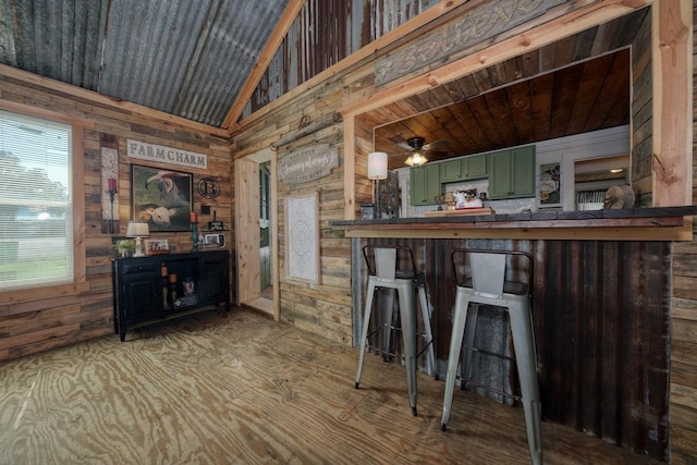 bar featuring ceiling fan, wooden ceiling, lofted ceiling, wooden walls, and green cabinetry