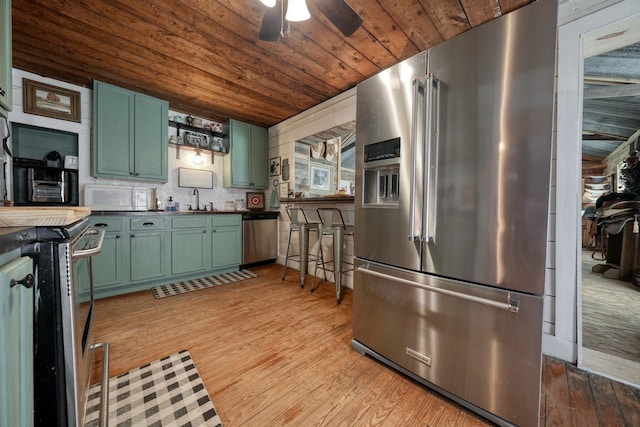 kitchen featuring ceiling fan, stainless steel appliances, light hardwood / wood-style floors, wood ceiling, and green cabinetry