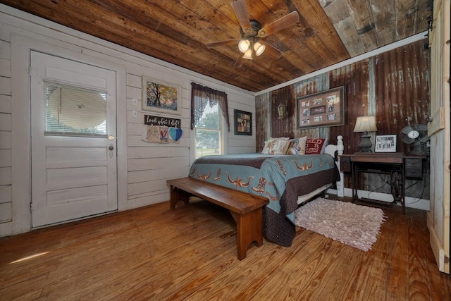 bedroom with hardwood / wood-style floors, ceiling fan, wood walls, and wood ceiling