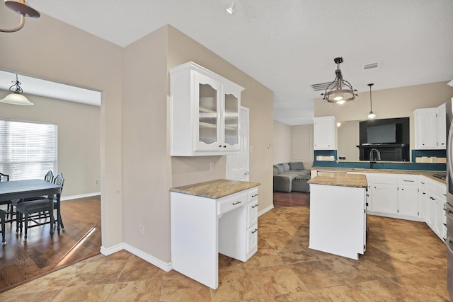 kitchen with white cabinets, decorative light fixtures, and kitchen peninsula