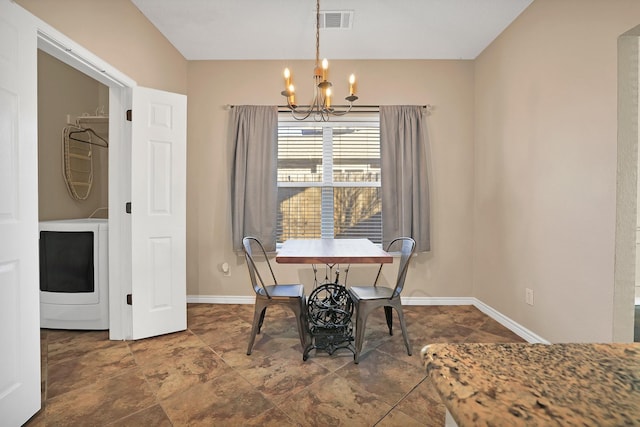 dining area with washer / dryer and a chandelier