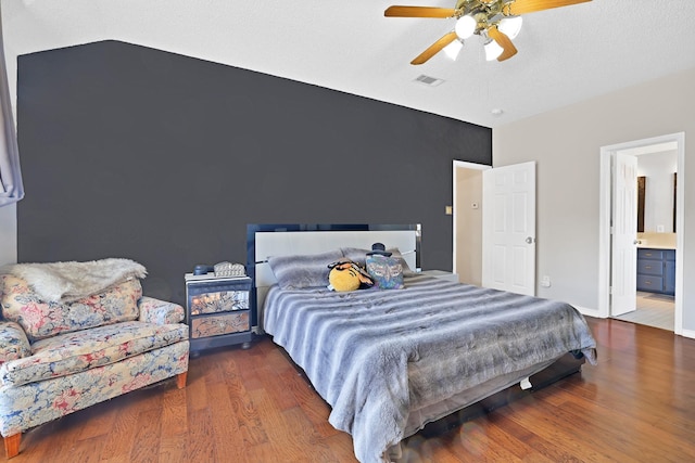 bedroom with connected bathroom, ceiling fan, and dark hardwood / wood-style flooring