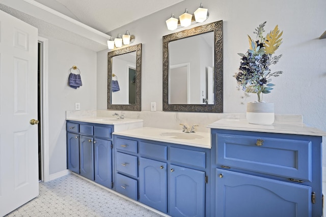 bathroom with vanity, a textured ceiling, and vaulted ceiling