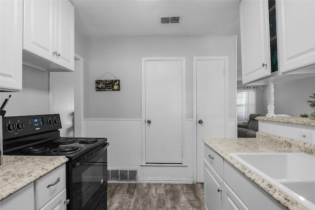 kitchen featuring white cabinetry, electric range, sink, dark wood-type flooring, and a textured ceiling