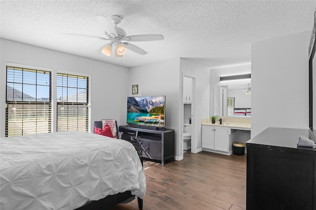 bedroom featuring a textured ceiling, connected bathroom, ceiling fan, and dark hardwood / wood-style floors