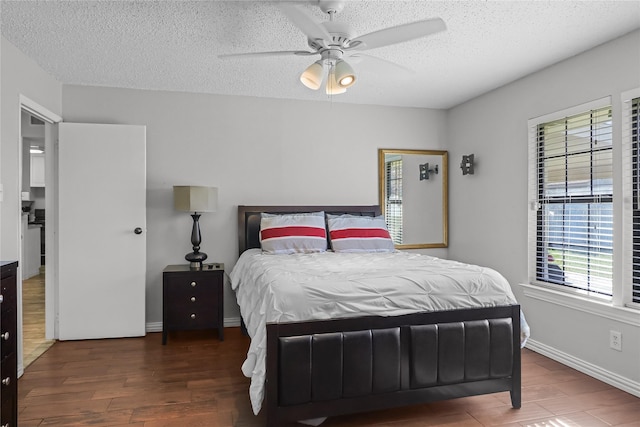 bedroom featuring dark hardwood / wood-style floors, ceiling fan, and a textured ceiling