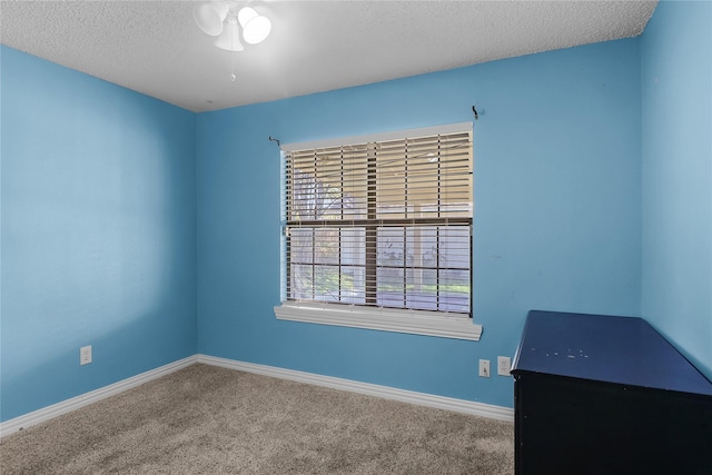 spare room featuring ceiling fan, carpet floors, and a textured ceiling