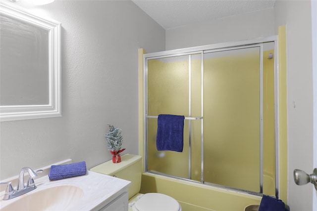 full bathroom featuring vanity, enclosed tub / shower combo, a textured ceiling, and toilet