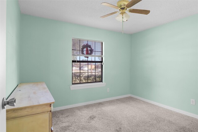 carpeted empty room featuring a textured ceiling and ceiling fan