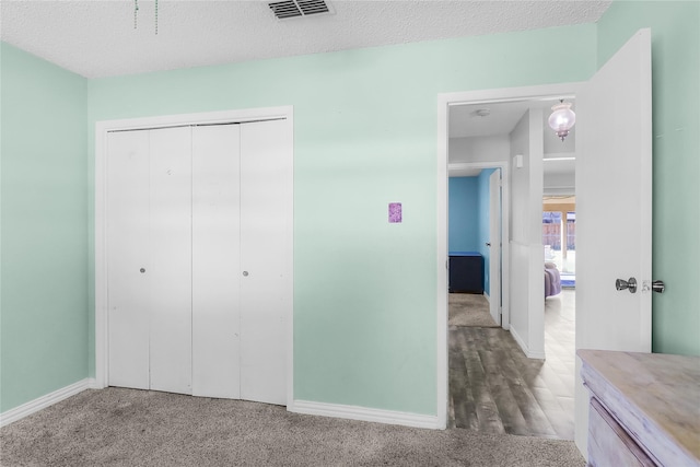 bedroom with a closet, hardwood / wood-style floors, and a textured ceiling