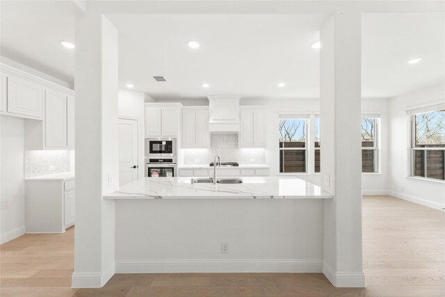 kitchen with stainless steel gas cooktop, sink, light hardwood / wood-style flooring, dishwasher, and white cabinetry