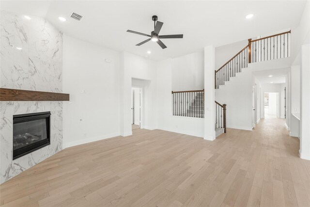 living room with ceiling fan, wood-type flooring, a fireplace, and vaulted ceiling