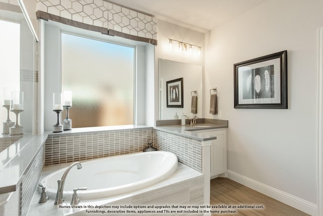 bathroom featuring vanity, tiled tub, and hardwood / wood-style floors