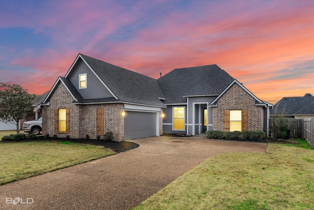 view of property featuring a garage and a lawn