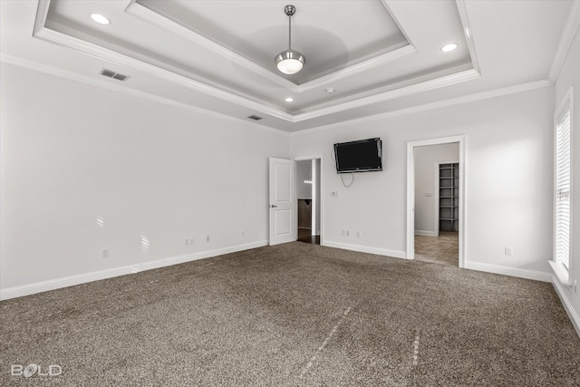 unfurnished bedroom with a raised ceiling, ornamental molding, carpet floors, and multiple windows