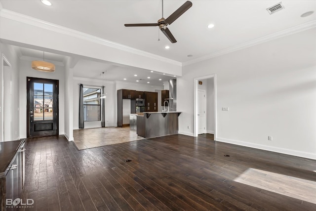 unfurnished living room featuring dark wood-type flooring, ceiling fan, and crown molding