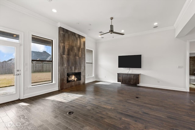 unfurnished living room featuring ceiling fan, dark hardwood / wood-style flooring, ornamental molding, and a fireplace