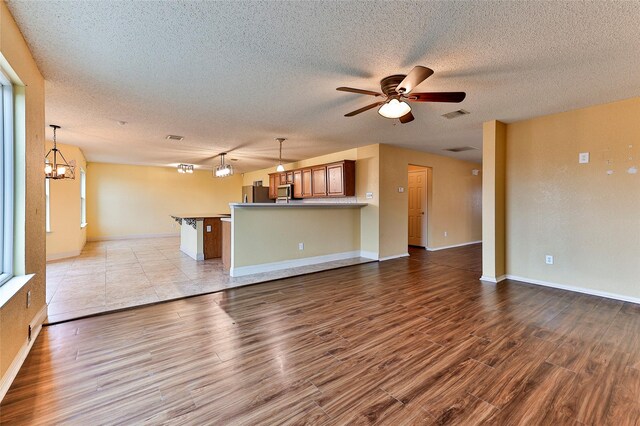 carpeted empty room featuring a textured ceiling and ceiling fan